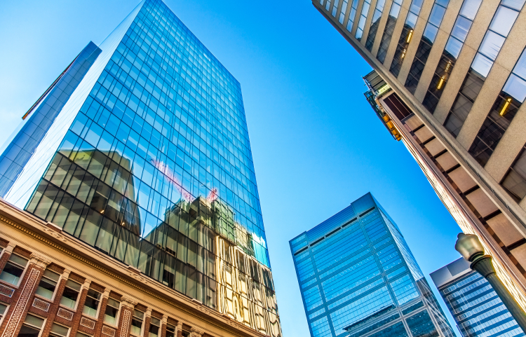 The reflection of financial buildings cast in the glass of towering skyscrapers